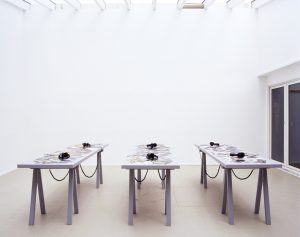 Photograph of the three tables with sets of headphones on them at the PLOTS installation.